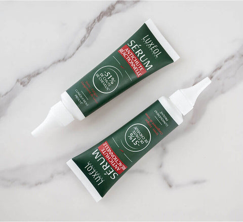 Flat lay of two Reactive Hair Loss Serum tubes on marble for product range.